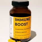 Reeleef Immune Boost Glas mit Kapseln vor dem Glass. Neem Pulver in Neem Kapseln zur Unterstützung des Immune Systems und der Abwehrkräfte