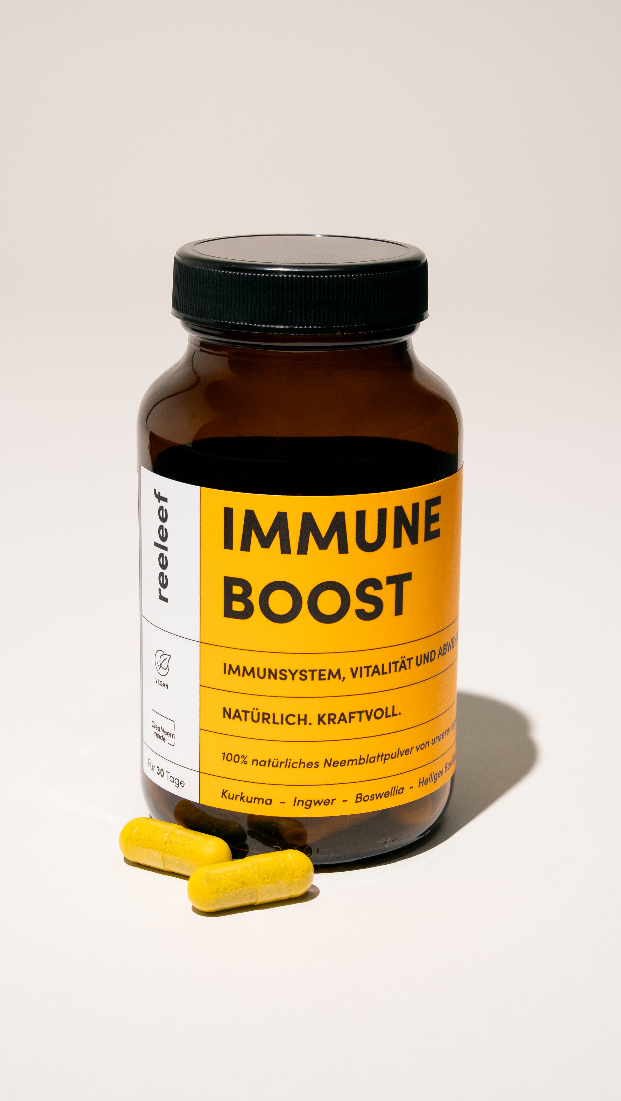 Reeleef Immune Boost Glas mit Kapseln vor dem Glass. Neem Pulver in Neem Kapseln zur Unterstützung des Immune Systems und der Abwehrkräfte